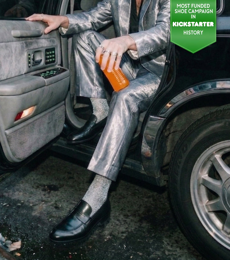 Man stepping out of limo wearing a silver suit and men's Italian black leather loafer dress shoes